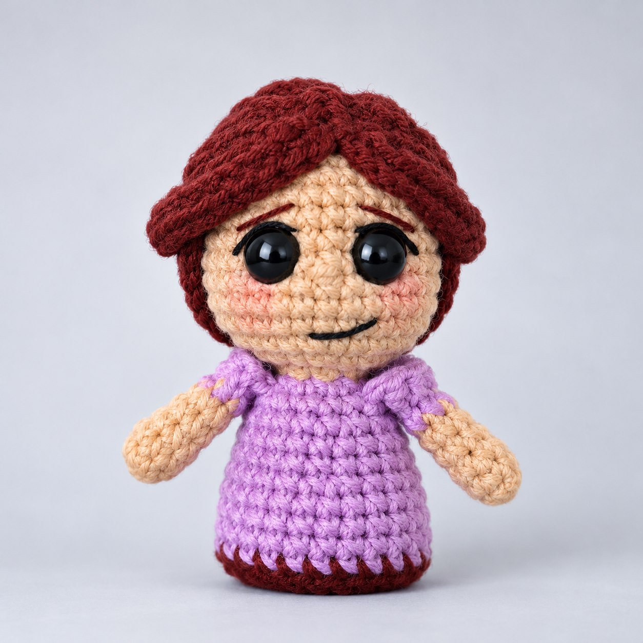 Boneca de amigurumi com base reta, cabelo ruivo e roupa lilás