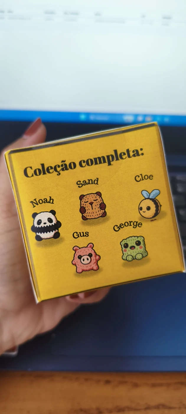 Caixa surpresa amarela com interrogações, o mesmo modelo usado na coleção Comidinhas